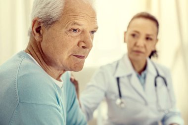 Tıbbi Danışma sırasında bakan dalgın emekli adam üzgün