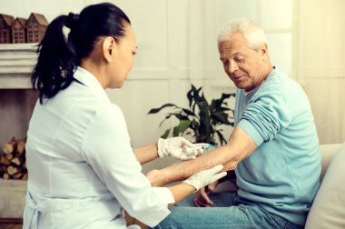 Cesur emekli hasta aşı sırasında gülümseyen