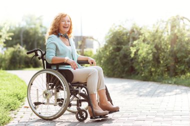 Radyant hanımefendi açık havada tekerlekli sandalyede otururken devre dışı