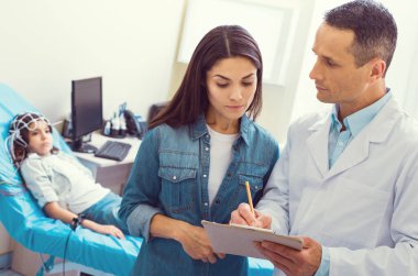 Endişeli doktor ve anne küçük kız tanısında tartışıyor