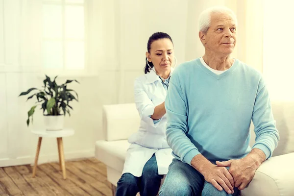 Médecin féminin vérifiant les poumons du gentleman aîné — Photo