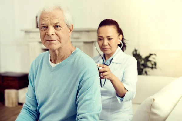 Un anciano reflexivo revisando los pulmones en el hospital — Foto de Stock