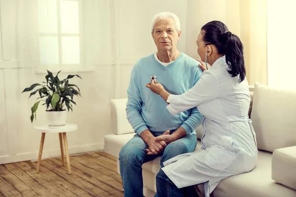 Enfermera escuchando los pulmones de un caballero retirado — Foto de Stock