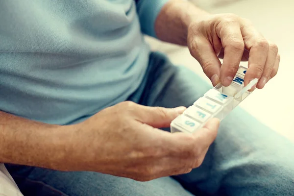 Close up of senior man opening weekly pill organizer — Stock Photo, Image