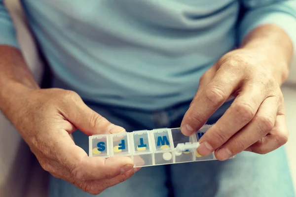 Ampliación de la mirada en caballero de edad avanzada que toma medicamentos —  Fotos de Stock