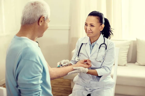 Medveten sjuksköterska ler medan vaccinerande pensionerad man — Stockfoto