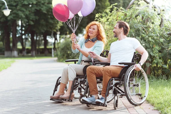 Marido y esposa de mente positiva sonriendo mientras sostienen globos — Foto de Stock