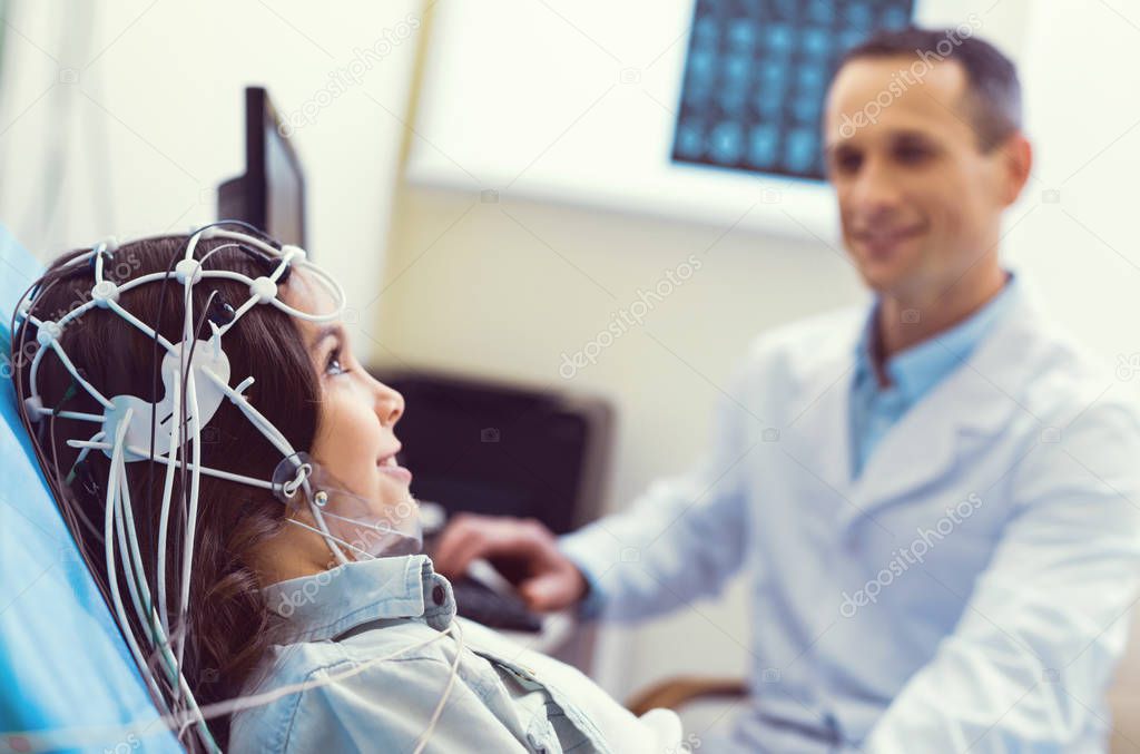 Positive minded little girl undergoing electroencephalography