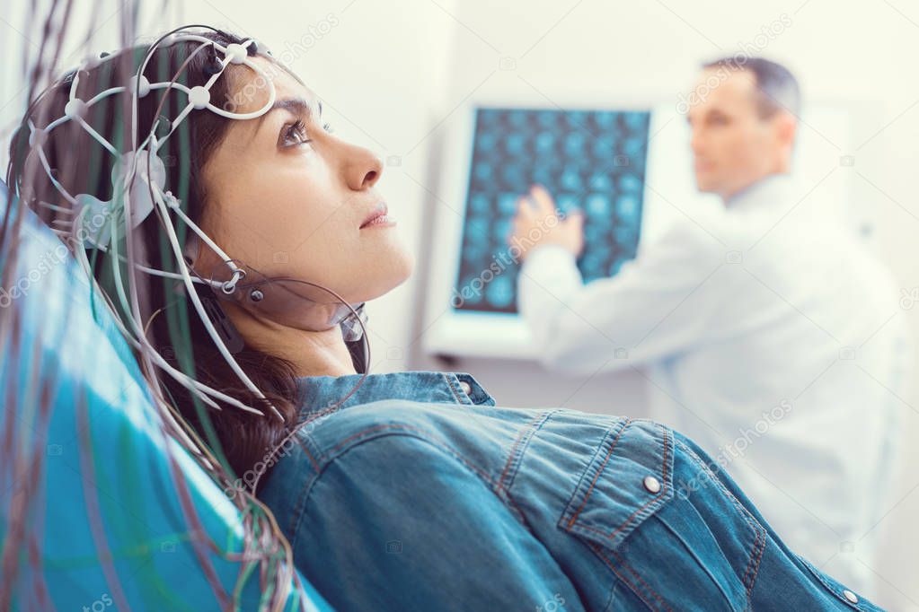 Close up of young woman getting brain analyzed by electroencephalograph