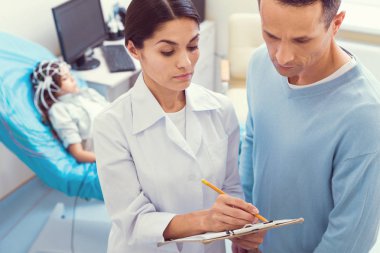 Doktor ve üst üzerinde küçük kızın tanı söz