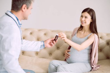 Teşekkür ederiz. Gülümseyen ve ilacı ona doktor bakarken mutlu güzel hoş kadın