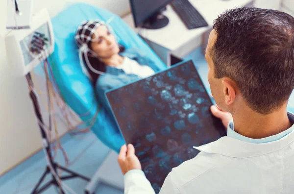 Männliche Labormitarbeiterin bei der Analyse des MRI-Scans während der Elektroenzephalographie — Stockfoto