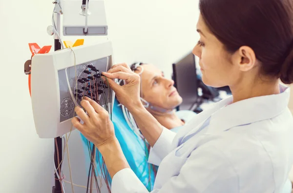 Labormitarbeiterin beim Aufbau einer Elektroenzephalographie-Maschine — Stockfoto