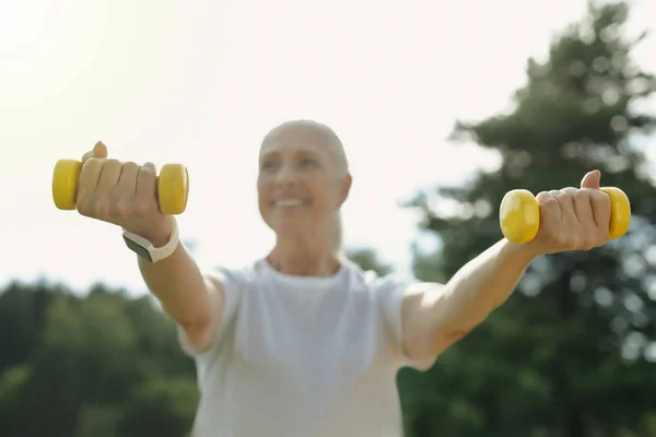 Positivo mente aposentado mulher treinando com pesos — Fotografia de Stock