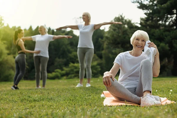 Mulher aposentada feliz irradiando depois de se exercitar ao ar livre — Fotografia de Stock