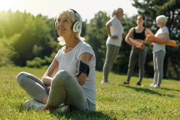 Müzik dinlerken gülümseyen güzel kadın kıdemli — Stok fotoğraf