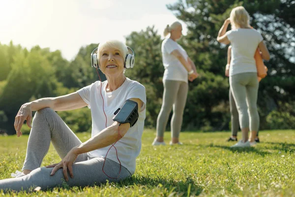 Alegre anciana escuchando música después de entrenar fitness — Foto de Stock