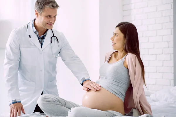 Mulher positiva agradável olhando para seu médico — Fotografia de Stock