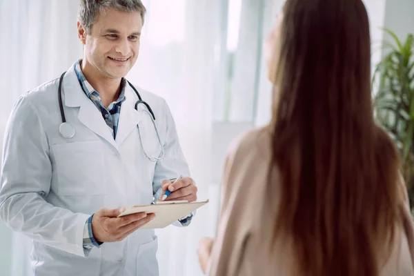 Happy cheerful doctor taking notes — Stock Photo, Image