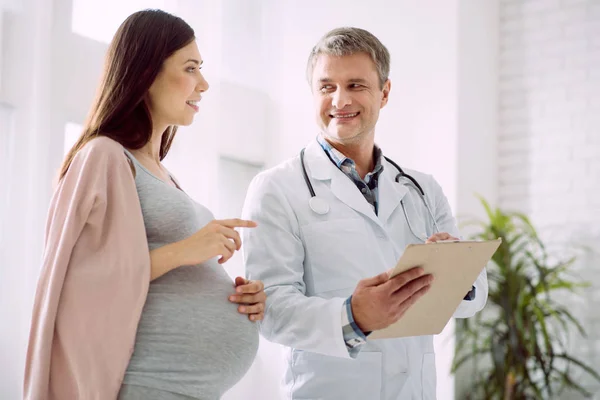 Happy pregnant woman talking to her doctor — Stock Photo, Image