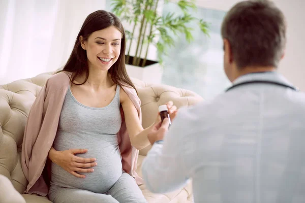 Щаслива вагітна жінка бере пляшку — стокове фото
