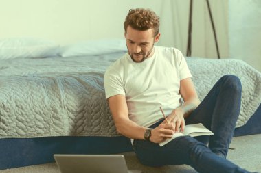 Akıllı genç beyefendi evde okurken not almak