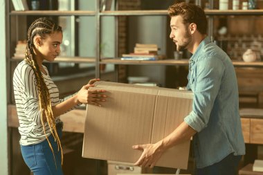 Yardıma var. Gençlerin yeni düz hareket ederken şeyler ambalaj ile yardım seven üzerinde yan görünüm.