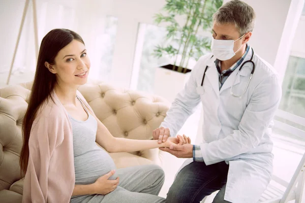 Милая беременная женщина проверяет пульс. — стоковое фото