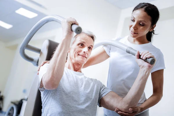 Begeisterter Rentner mit Fitnessgeräten im Reha-Zentrum — Stockfoto