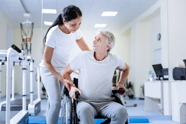 Preoccupato uomo disabile seduto su una sedia a rotelle e guardando il suo medico — Foto Stock