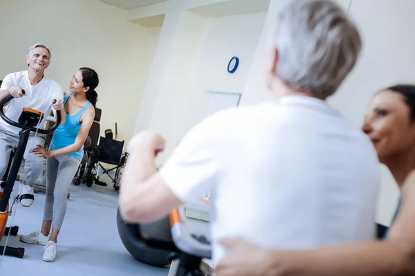 Känslomässiga baby boomer leende medan du gör övningarna i en vårdcentral — Stockfoto