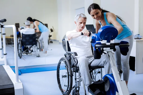 Ενεργητικός άντρας στο αναπηρικό καροτσάκι κατάρτισης σε κέντρο αποκατάστασης — Φωτογραφία Αρχείου