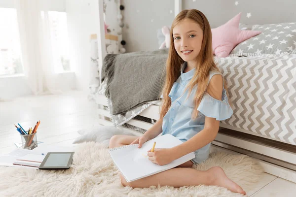 Relaxed schoolgirl doing her home tasks — Stock Photo, Image