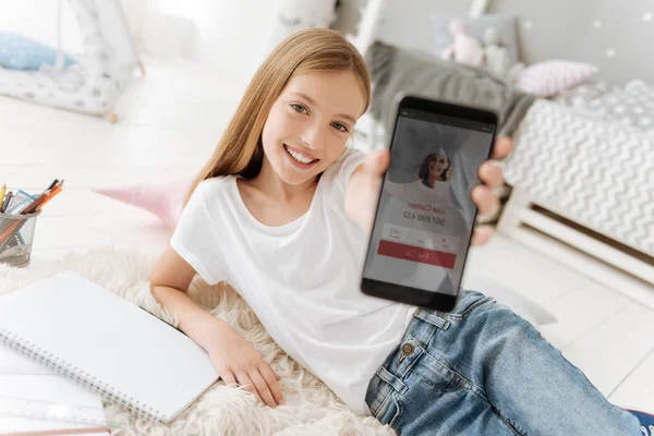 Encantadora niña demostrando su nuevo smartphone —  Fotos de Stock