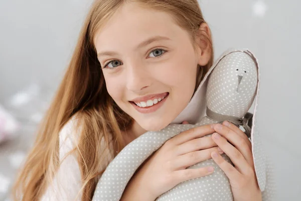 Позитивный ребенок обнимает игрушку ручной работы — стоковое фото