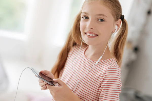 Étudiante joyeuse utilisant son appareil écoutant de la musique — Photo