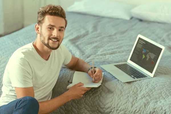 Freelancer alegre sorrindo para a câmera enquanto trabalhava em casa — Fotografia de Stock