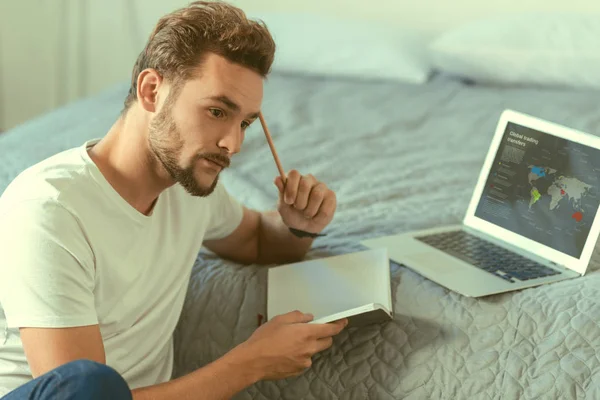 Fundersam gentleman generera idéer med anteckningsboken i händer — Stockfoto