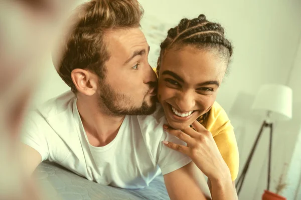 Loving boyfriend kissing girl while posing for selfie — Stock Photo, Image