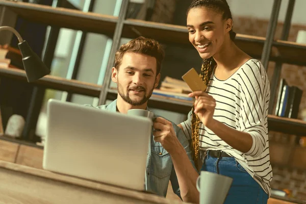 Jóvenes alegres que pagan por compras en línea — Foto de Stock