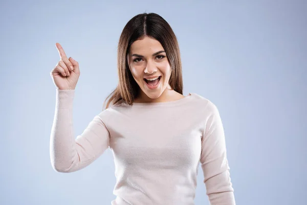 Delighted happy woman pointing up with her finger — Stock Photo, Image