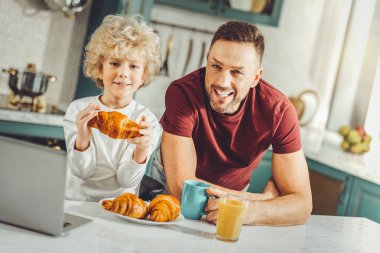 Yakışıklı baba ve oğul kruvasan ve portakal suyu