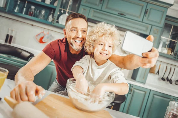 Father and son smiling broadly while making photo together
