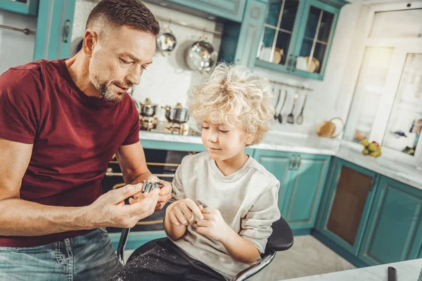 Bärtiger Vater hält Backformen in der Hand und kocht mit Sohn Kekse — Stockfoto