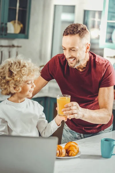 Opieka nad kochającego Ojca, przynosząc szklanki soku pomarańczowego dla syna — Zdjęcie stockowe
