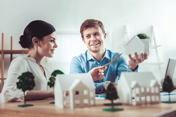 Alegre hembra examinando modelo de casa — Foto de Stock