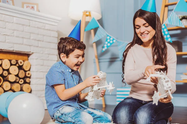 Alegre exuberante mulher e menino brincando com presentes de aniversário — Fotografia de Stock