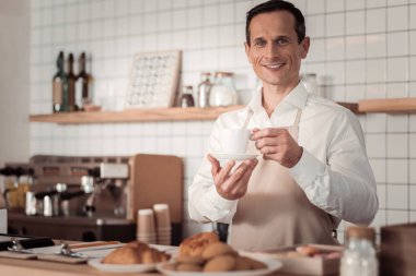 Bir fincan kahve tutan olumlu iyi adam