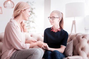 Sakin kız kanepede oturan ve annesine bakarak gülen