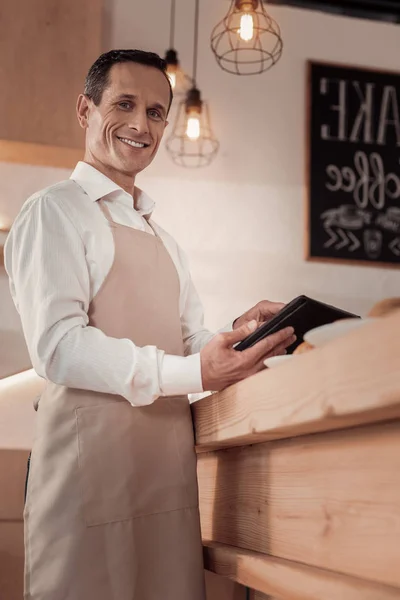 Un hombre de negocios alegre y positivo dirigiendo un café —  Fotos de Stock